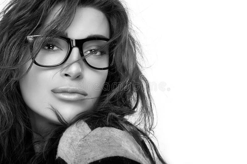 Gorgeous brunette fashion model girl with casual hairstyle wearing trendy glasses. Cool trendy eyewear portrait. Closeup in black and white with copy space for text. Gorgeous brunette fashion model girl with casual hairstyle wearing trendy glasses. Cool trendy eyewear portrait. Closeup in black and white with copy space for text