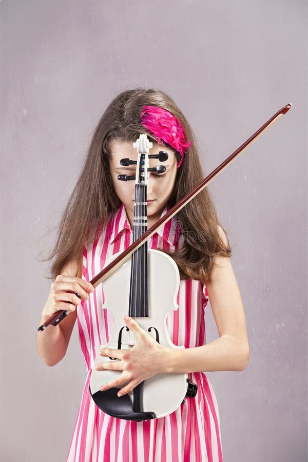 Female child playing the violin with gray background. Female child playing the violin with gray background