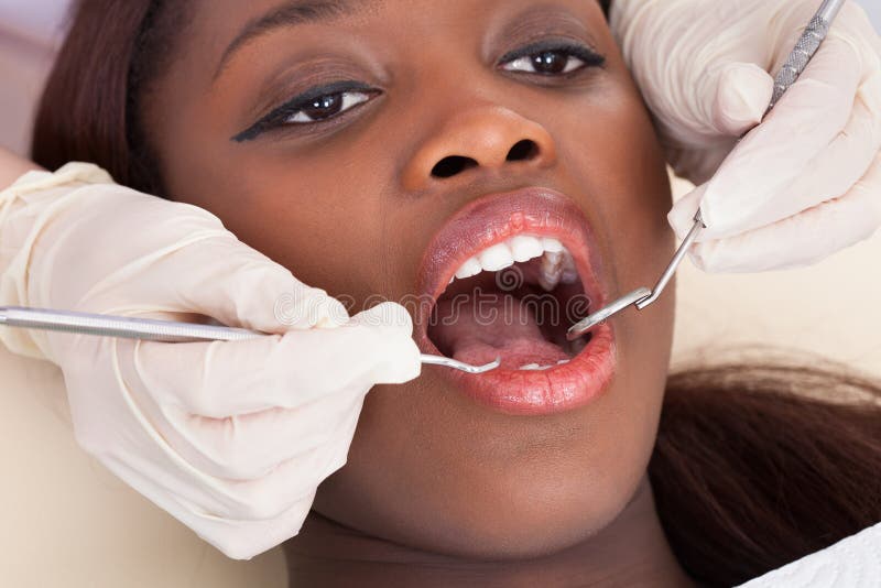 Żeński pacjent sprawdza dentystą fotografia stock Żeński pacjent sprawdza dentystą fotografia stock
