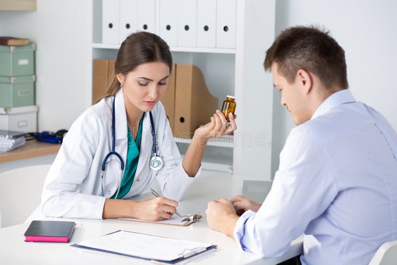 Żeńskiej medycyny doktorskie przepisuje pigułki jej męski pacjent obraz stock Żeńskiej medycyny doktorskie przepisuje pigułki jej męski pacjent obraz stock