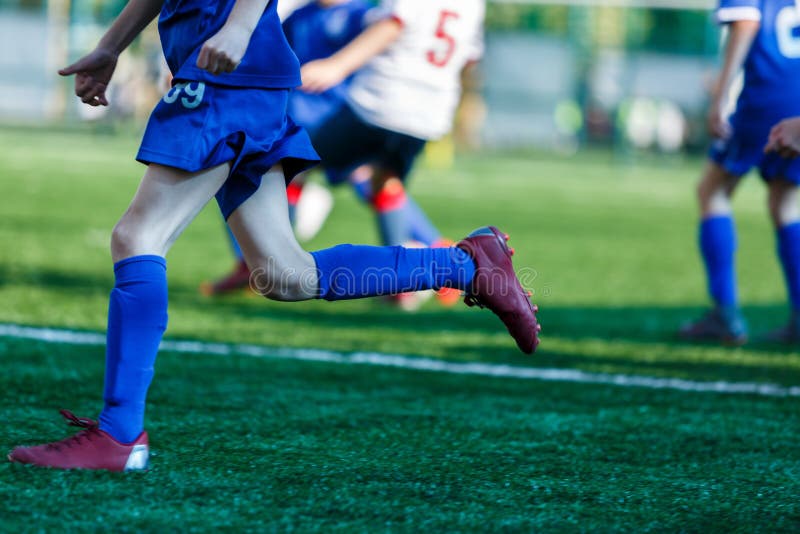 F?sforo de futebol j?nior Meninos no fósforo de futebol branco azul do jogo do sportswear no passo de futebol Estádio de futebol, imagem de stock royalty free F?sforo de futebol j?nior Meninos no fósforo de futebol branco azul do jogo do sportswear no passo de futebol Estádio de futebol, imagem de stock royalty free