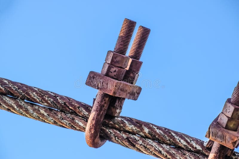Fastening clamp on the steel cable of the bridge. Connecting elements of construction
