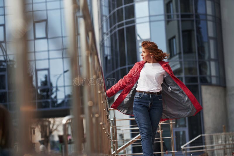 Fa un po' più caldo Una bella donna adulta con un caldo cappotto rosso ha camminato in città nel weekend fotografia stock libera da diritti Fa un po' più caldo Una bella donna adulta con un caldo cappotto rosso ha camminato in città nel weekend fotografia stock libera da diritti