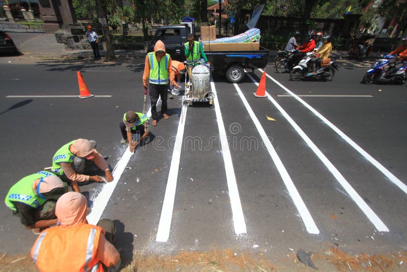 Workers made a traffic line to regulate the flow in Surakarta, Java, Indonesia. Making its own line of traffic directed to the marker for road users passing to avoid exceeding the limit. Workers made a traffic line to regulate the flow in Surakarta, Java, Indonesia. Making its own line of traffic directed to the marker for road users passing to avoid exceeding the limit.