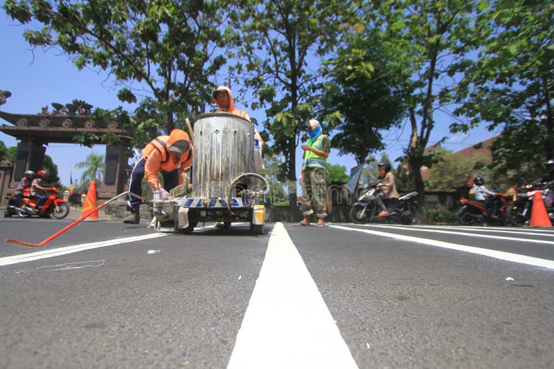 Workers made a traffic line to regulate the flow in Surakarta, Java, Indonesia. Making its own line of traffic directed to the marker for road users passing to avoid exceeding the limit. Workers made a traffic line to regulate the flow in Surakarta, Java, Indonesia. Making its own line of traffic directed to the marker for road users passing to avoid exceeding the limit.