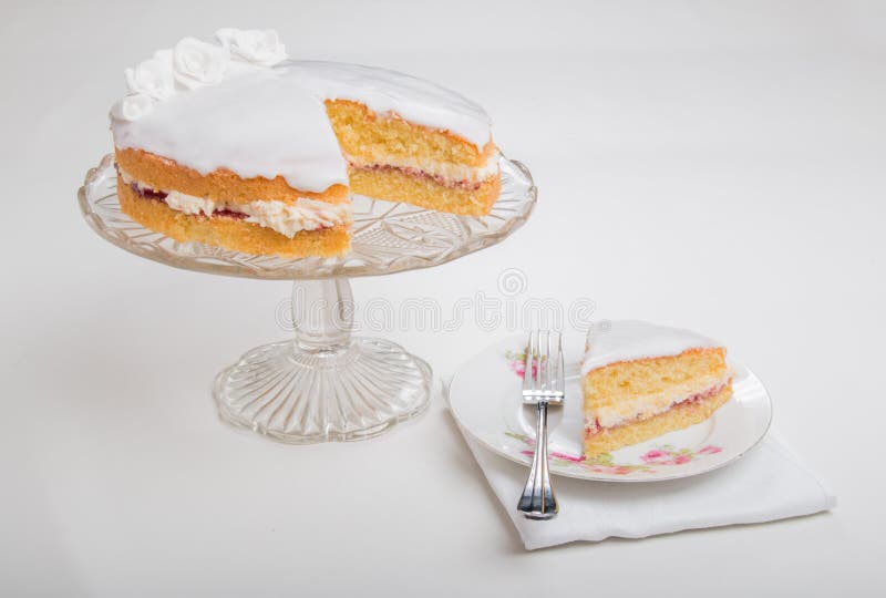 Fabricación de los bizcochos esponjosos, de la extensión de la torta con el atasco/el coto y del buttercream y helado con las ros imagen de archivo libre de regalías Fabricación de los bizcochos esponjosos, de la extensión de la torta con el atasco/el coto y del buttercream y helado con las ros imagen de archivo libre de regalías
