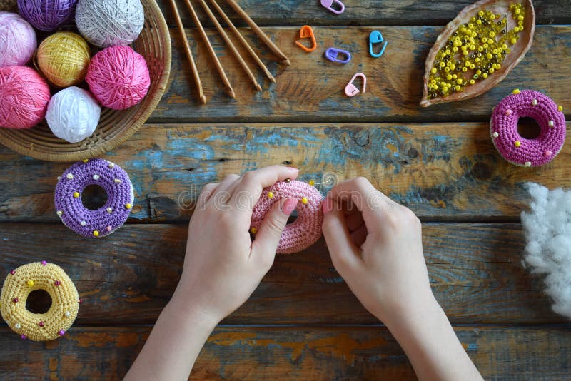 Making crochet amigurumi donuts. The toy for babies or trinket. On the table threads, needles, hook, cotton yarn. Handmade gift. DIY crafts concept. Step 2. Stuff the toy with padding polyester. Making crochet amigurumi donuts. The toy for babies or trinket. On the table threads, needles, hook, cotton yarn. Handmade gift. DIY crafts concept. Step 2. Stuff the toy with padding polyester