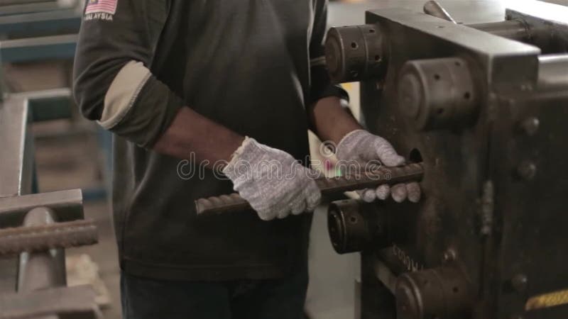Fabrikarbeiter, der den Stahlstab in einen maschinenseitigen Winkel versetzt