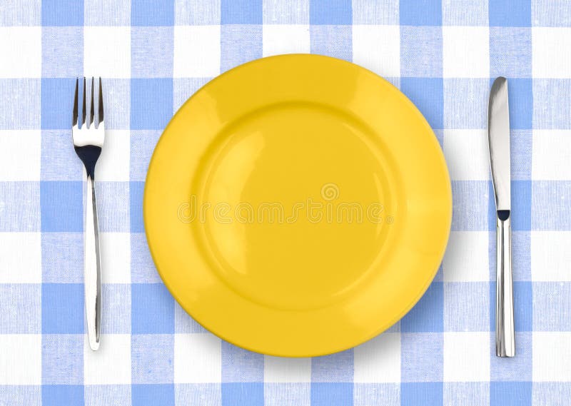 Faca, placa amarela e forquilha no tablecloth verific fotografia de stock Faca, placa amarela e forquilha no tablecloth verific fotografia de stock
