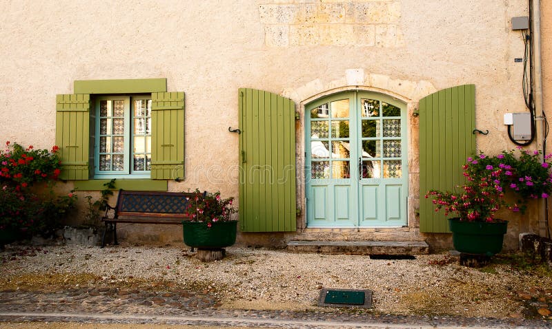 Facade with olive green shutters, light blue window and door, bench and flowers in Saint Jean de Cole Dordogne France. Window color reflection background stock images, royalty-free photos and pictures