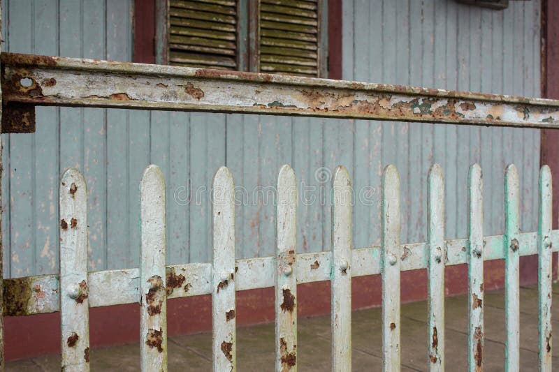 Facade of old abandoned house with rusty metal fence and grungy weathered green wood wall royalty free stock image Facade of old abandoned house with rusty metal fence and grungy weathered green wood wall royalty free stock image