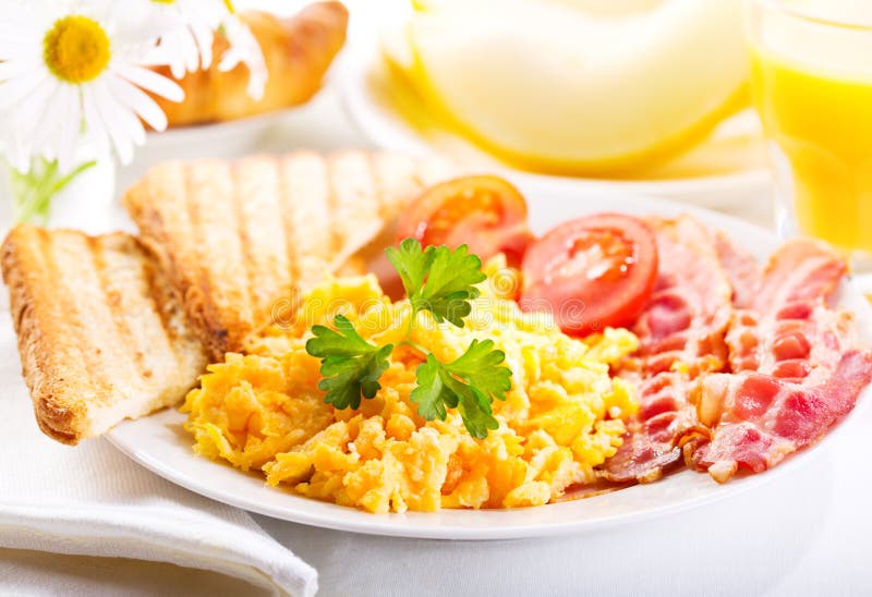 Faccia colazione con le uova, il succo ed i frutti rimescolati