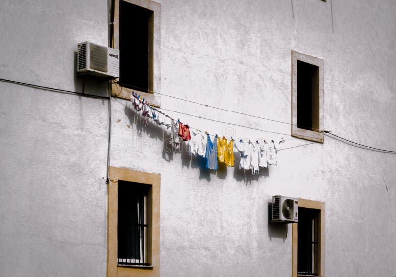 Facciata della casa bianca con bucato. abiti colorati sulla corda asciugati sul muro di un edificio in croazia fotografia stock libera da diritti