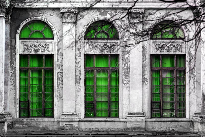Facciata di vecchia costruzione abbandonata con tre grandi finestre incurvate di vetro verde Fondo monocromatico immagini stock libere da diritti Facciata di vecchia costruzione abbandonata con tre grandi finestre incurvate di vetro verde Fondo monocromatico immagini stock libere da diritti