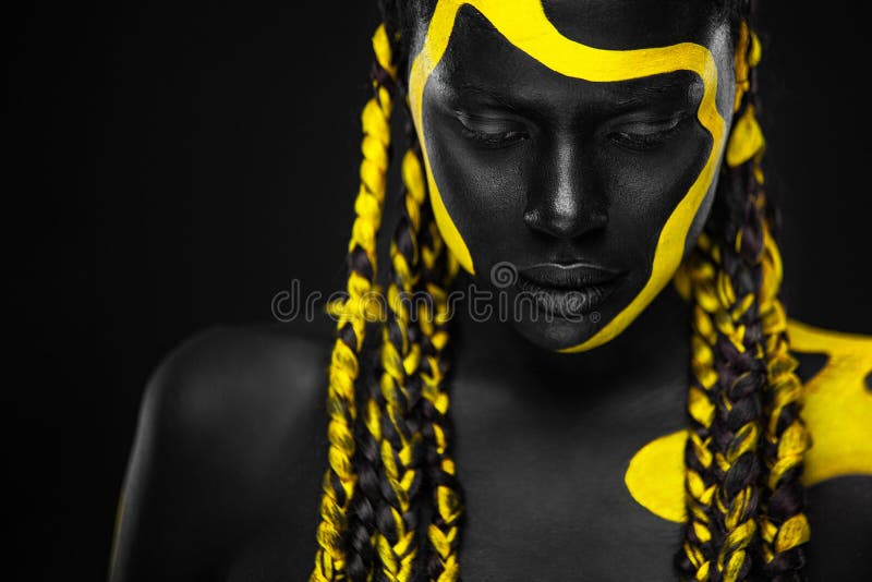 Yellow and black body paint. Woman with face art. Young girl with