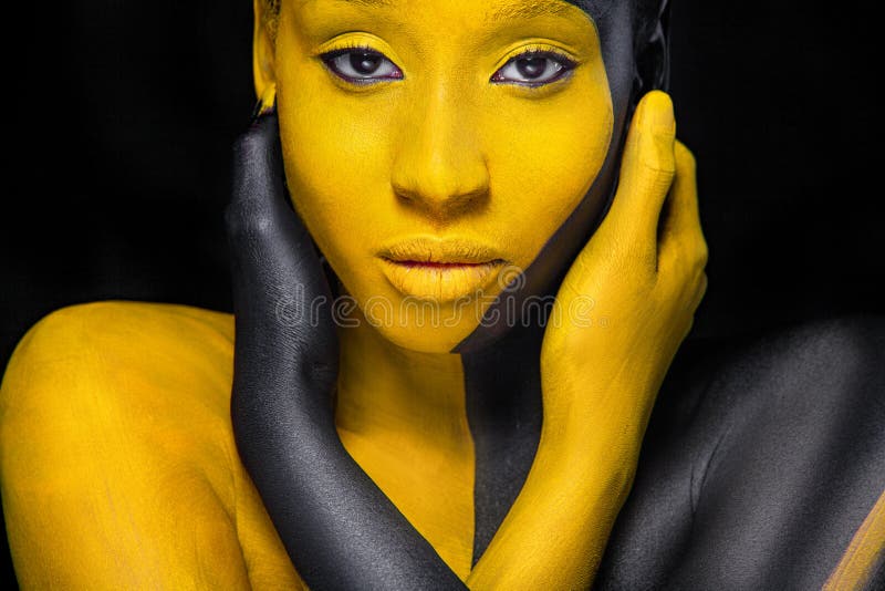 Yellow and black body paint. Woman with face art. Young girl with