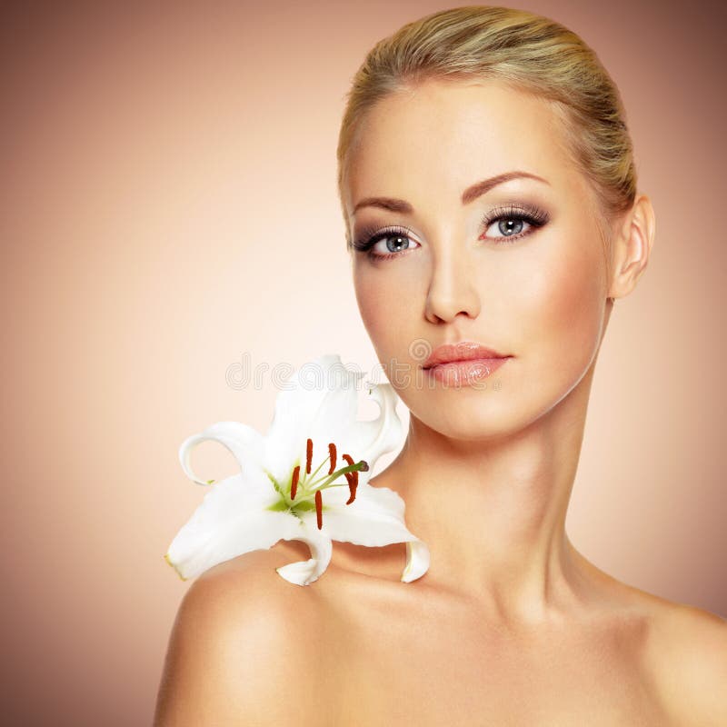 Face of a Beautiful woman with clean skin and white flower