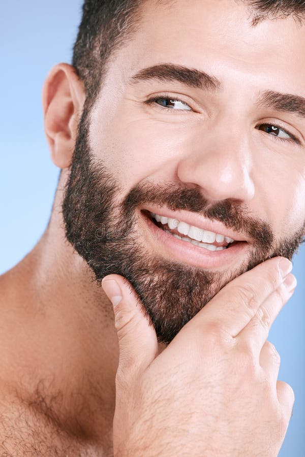 Face, beauty and skincare with a man model in studio on a blue background for natural wellness or grooming. Idea, beard