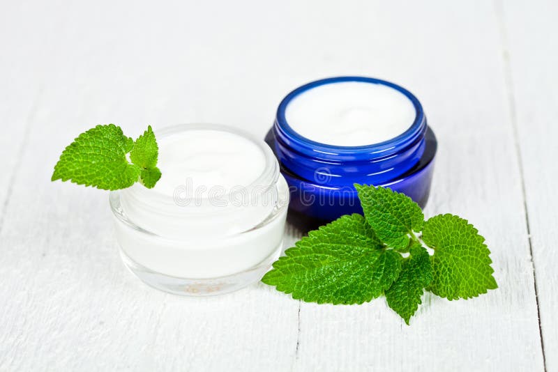 Face cream in jars with urtica leaves