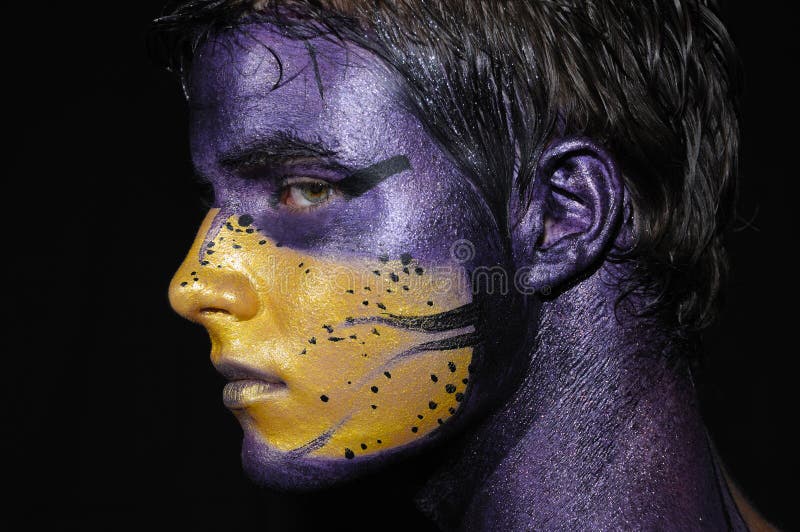 Portrait of young boy with artistic bodypaint drawing on face - isolated on black. Portrait of young boy with artistic bodypaint drawing on face - isolated on black