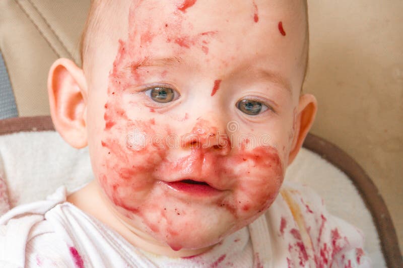 Face of dorty and messy baby eating snack royalty free stock image