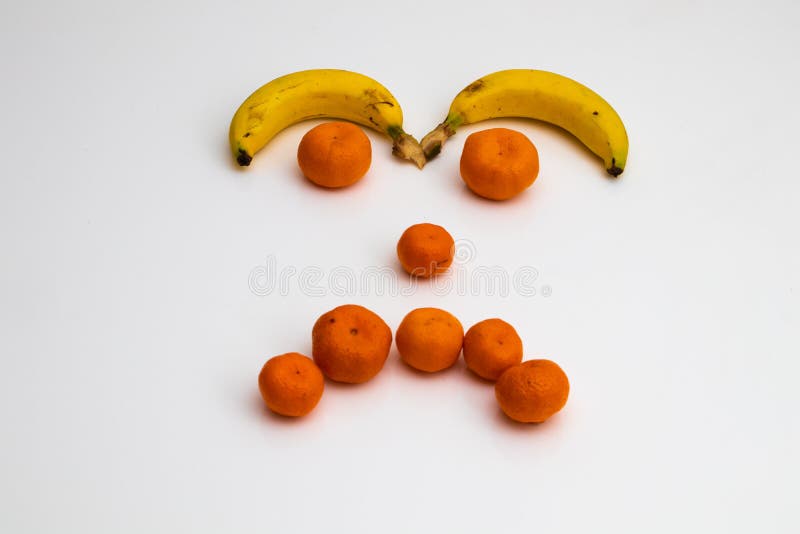Face from fruits on white background. face made with fresh fruits. banana, mandarin tangerine stock photography Face from fruits on white background. face made with fresh fruits. banana, mandarin tangerine stock photography
