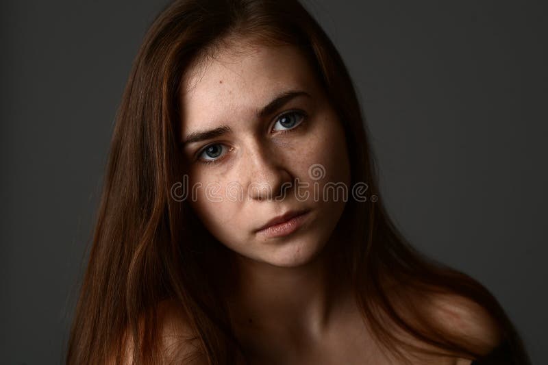 The face of a girl with beautiful hair and freckles in studio