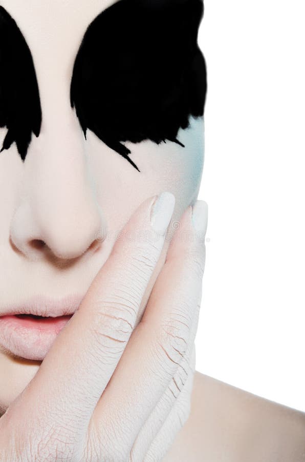 Face and hand of woman with black white makeup