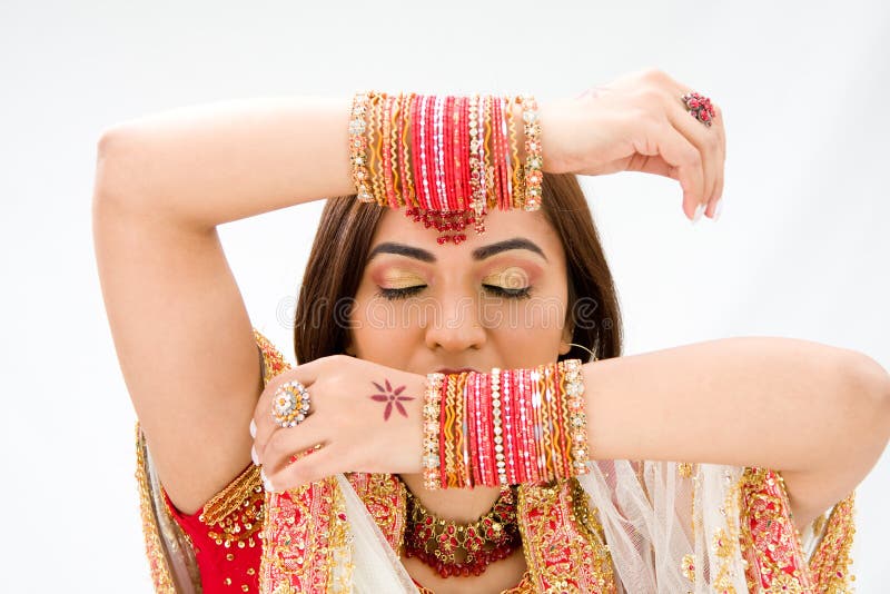 Beautiful face of a Bengali bride with her arms across her head covered with colorful bracelets and eyes closed, isolated. Beautiful face of a Bengali bride with her arms across her head covered with colorful bracelets and eyes closed, isolated