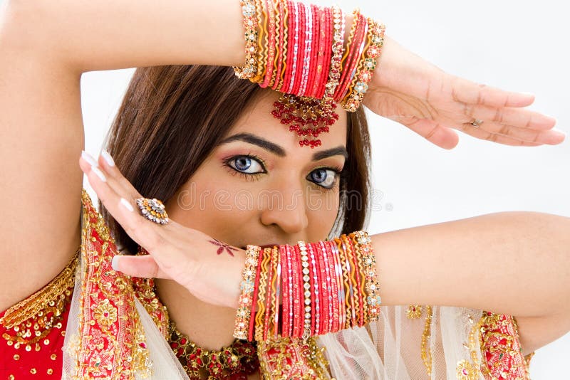 Beautiful face of a Bengali bride with her arms across her head covered with colorful bracelets, isolated. Beautiful face of a Bengali bride with her arms across her head covered with colorful bracelets, isolated