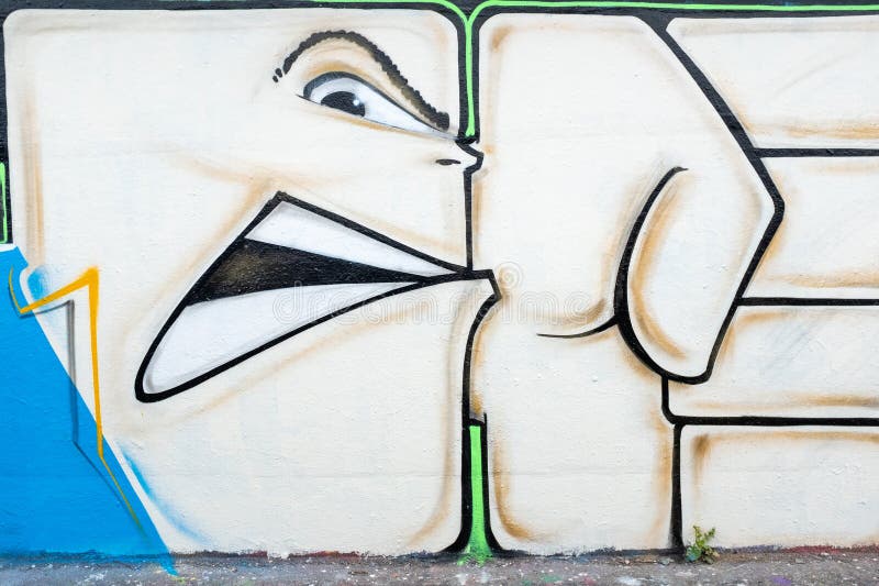 Graffiti art on a wall depicts a stylized, abstract face with exaggerated features. Shoreditch, UK royalty free stock photos