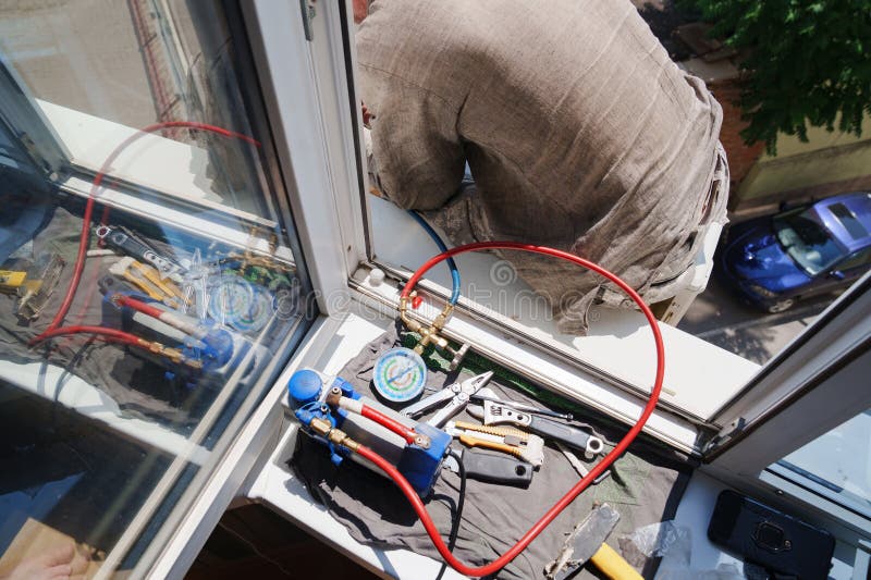 Without a Face. a Man Installs an External Air Conditioner. Dangerous