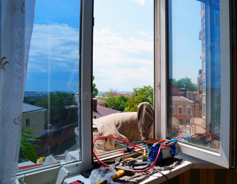 Without a Face. a Man Installs an External Air Conditioner. Dangerous