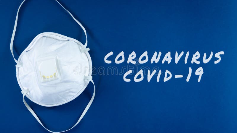 Face mask on blue background with corona virus written in white colour in conceptual image of public health threatening virus. Face mask on blue background with corona virus written in white colour in conceptual image of public health threatening virus