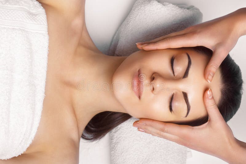 Face massage.  Close-up of young woman getting spa massage treatment at beauty spa salon.Spa skin and body care. Facial beauty