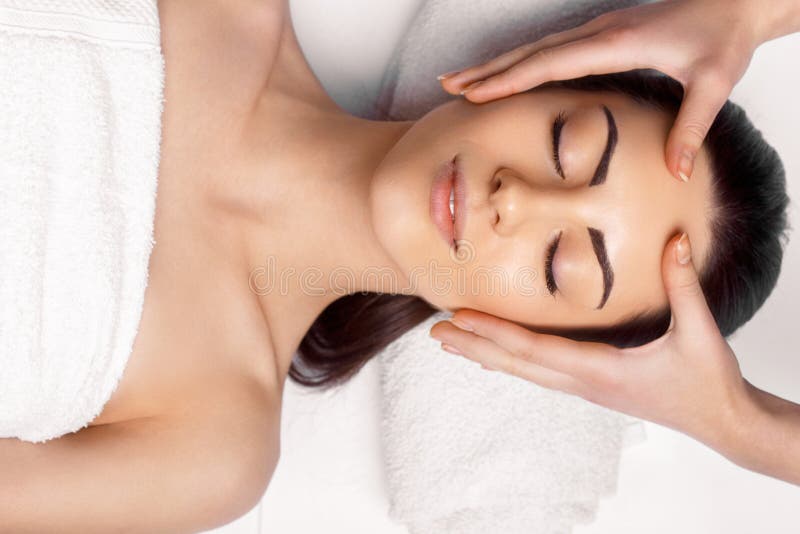 Face massage.  Close-up of young woman getting spa massage treatment at beauty spa salon.Spa skin and body care. Facial beauty