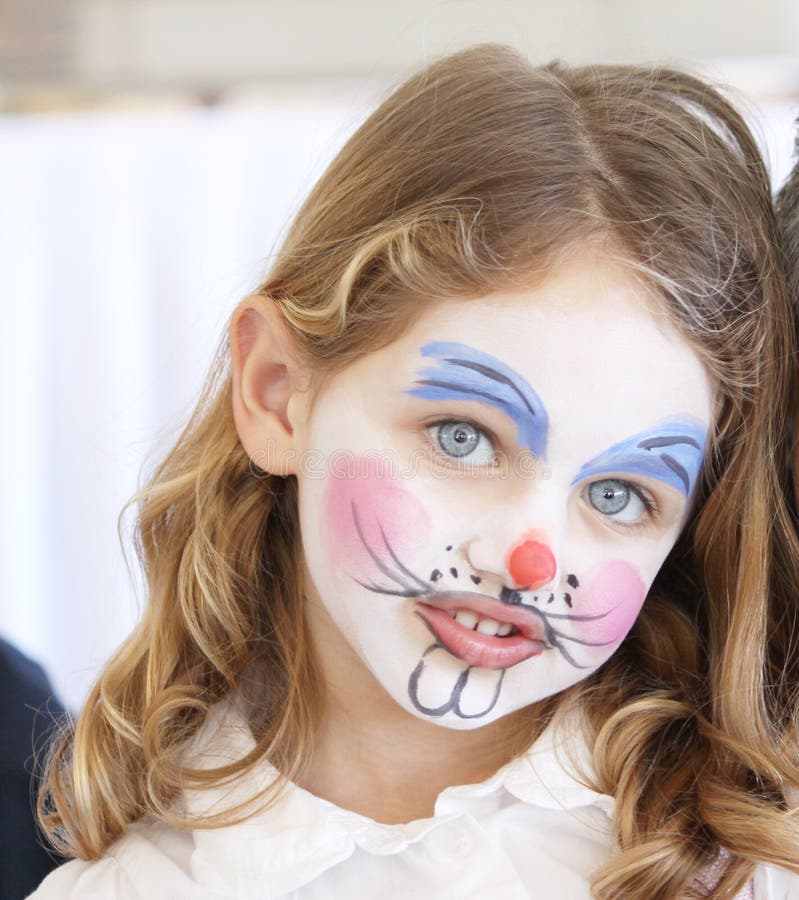 Portrait of a pretty caucasian girl with blue eyes with her face painted as a bunny rabbit. Portrait of a pretty caucasian girl with blue eyes with her face painted as a bunny rabbit
