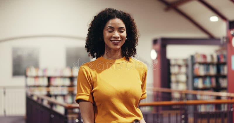 Face, teacher and happy woman in library for education, development and knowledge. Smile, librarian and person in school stock video footage