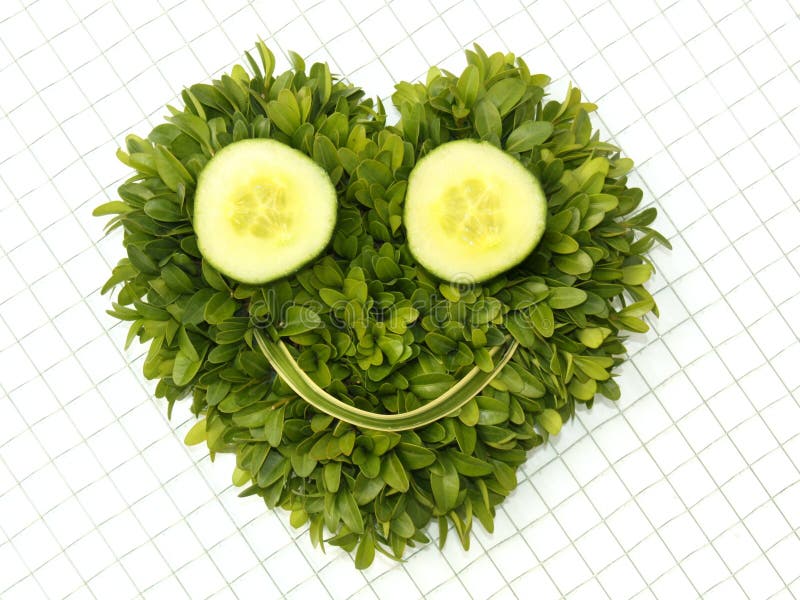 A heart-shaped smiley face created by green leafy grass and sliced cucumbers. A heart-shaped smiley face created by green leafy grass and sliced cucumbers.