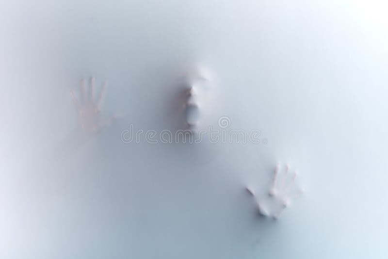 face with wide open mouth and raised hands, standing behind the fabric, glass wall,man asking help as the muder is killing him, white and black photo. face with wide open mouth and raised hands, standing behind the fabric, glass wall,man asking help as the muder is killing him, white and black photo.