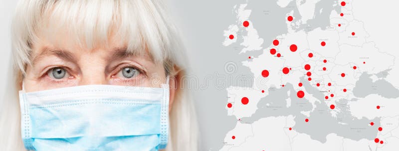 Face of a woman in a medical mask on a grey horizontal background. Covid-19 pandemic epidemic red areas on a global map