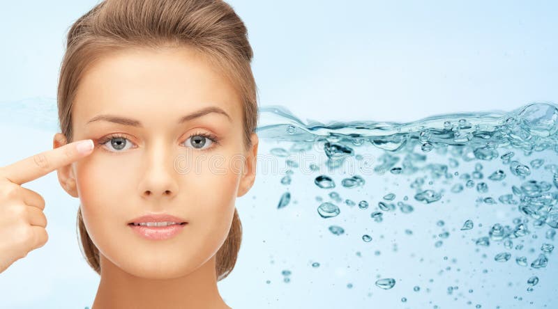 Face of young woman pointing finger to her eye stock photos Face of young woman pointing finger to her eye stock photos
