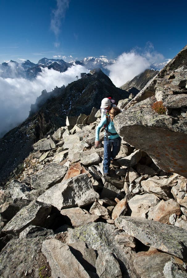 Mother with childcarrier with baby hiking on eggishorn. Mother with childcarrier with baby hiking on eggishorn