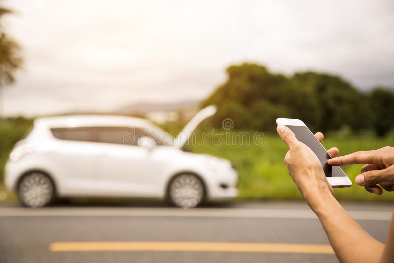 Facendo uso di una chiamata di telefono cellulare un meccanico di automobile perché l'automobile era rotta fotografia stock libera da diritti Facendo uso di una chiamata di telefono cellulare un meccanico di automobile perché l'automobile era rotta fotografia stock libera da diritti