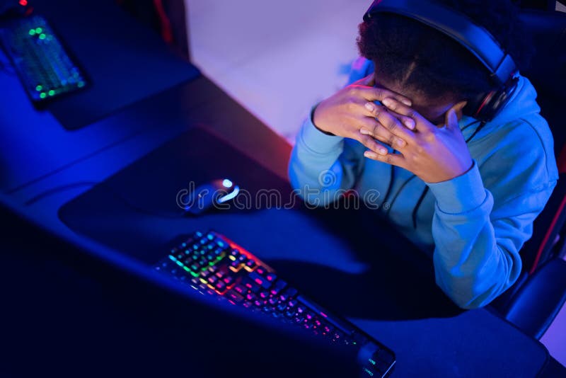 Facepalm snellisce una donna africana che non gioca a giocare con i videogiochi online computer emozioni aggressione neon color immagini stock libere da diritti