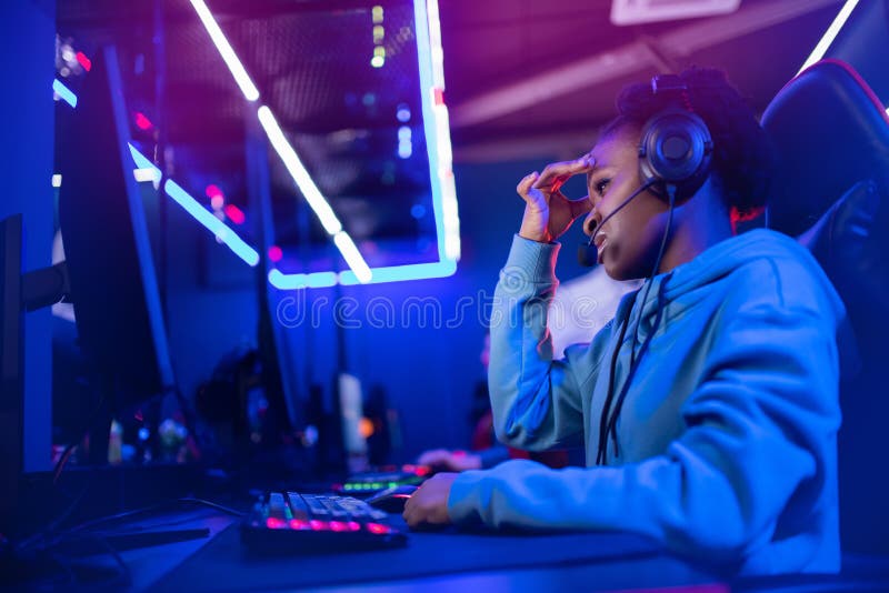 Facepalm snellisce una donna africana che non gioca a giocare con i videogiochi online computer emozioni aggressione neon color fotografia stock libera da diritti