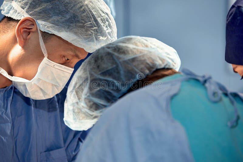 Faces of Surgeons Closeup during a Complex and Intense Operation