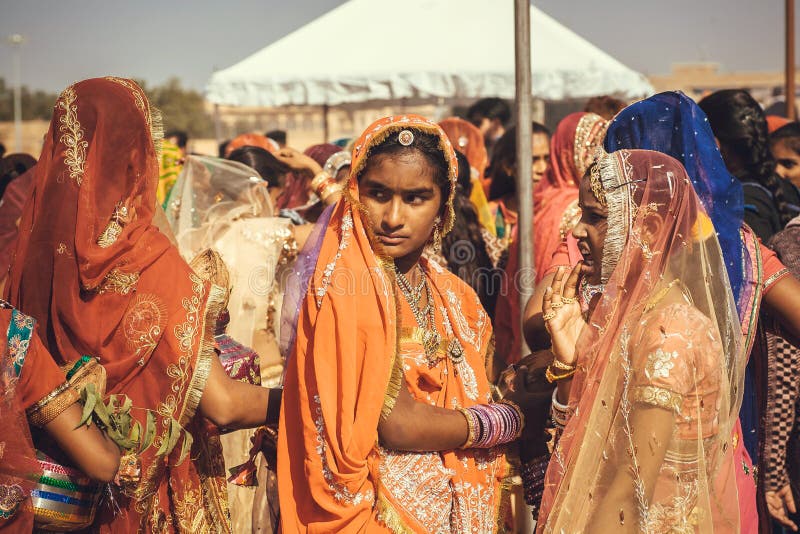 Faces of young women dressed traditional indian sari in crowd on the famous festival of Rajasthan