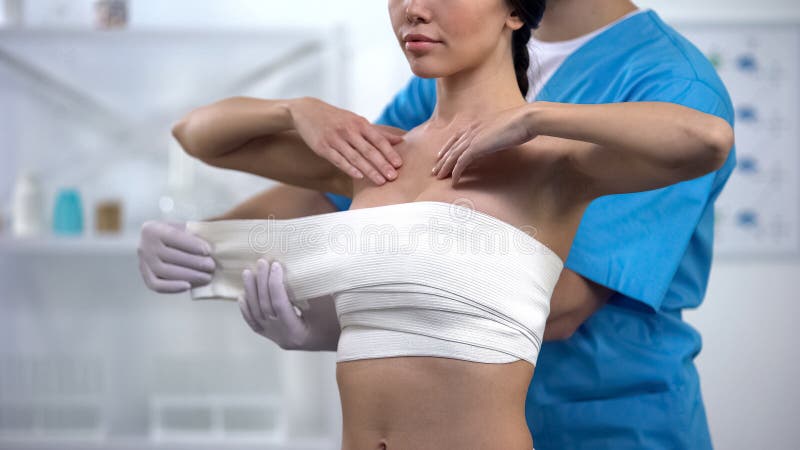 Fachowej chirurg plastyczny opakunkowej klatki piersiowej uciskowy żeński pacjent, zdrowie fotografia stock Fachowej chirurg plastyczny opakunkowej klatki piersiowej uciskowy żeński pacjent, zdrowie fotografia stock