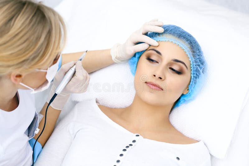 Fachowy beautician robi brew tatuażowi przy kobiety twarzą Stały brwi makeup w piękno salonie, zbliżenie pozaziemski zdjęcia royalty free Fachowy beautician robi brew tatuażowi przy kobiety twarzą Stały brwi makeup w piękno salonie, zbliżenie pozaziemski zdjęcia royalty free